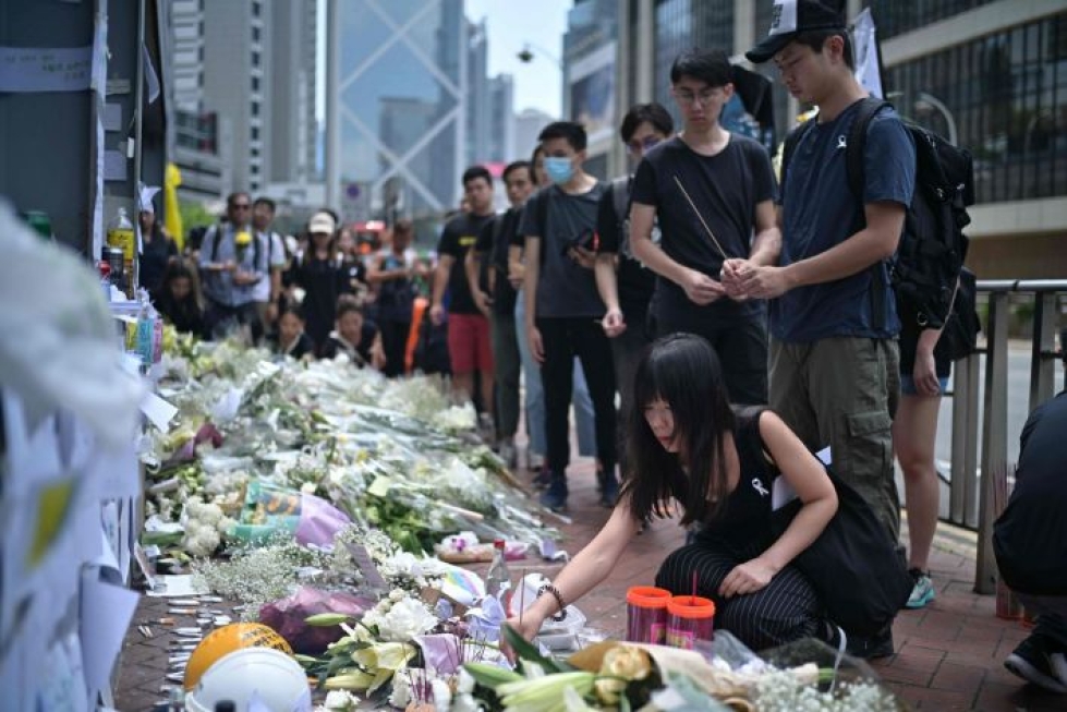 Hongkongissa mielenosoitusten johtajat ovat kehottaneet protestoijia tuomaan valkoisia kukkia paikalle, jonne mies putosi kuolemaansa.  LEHTIKUVA/AFP