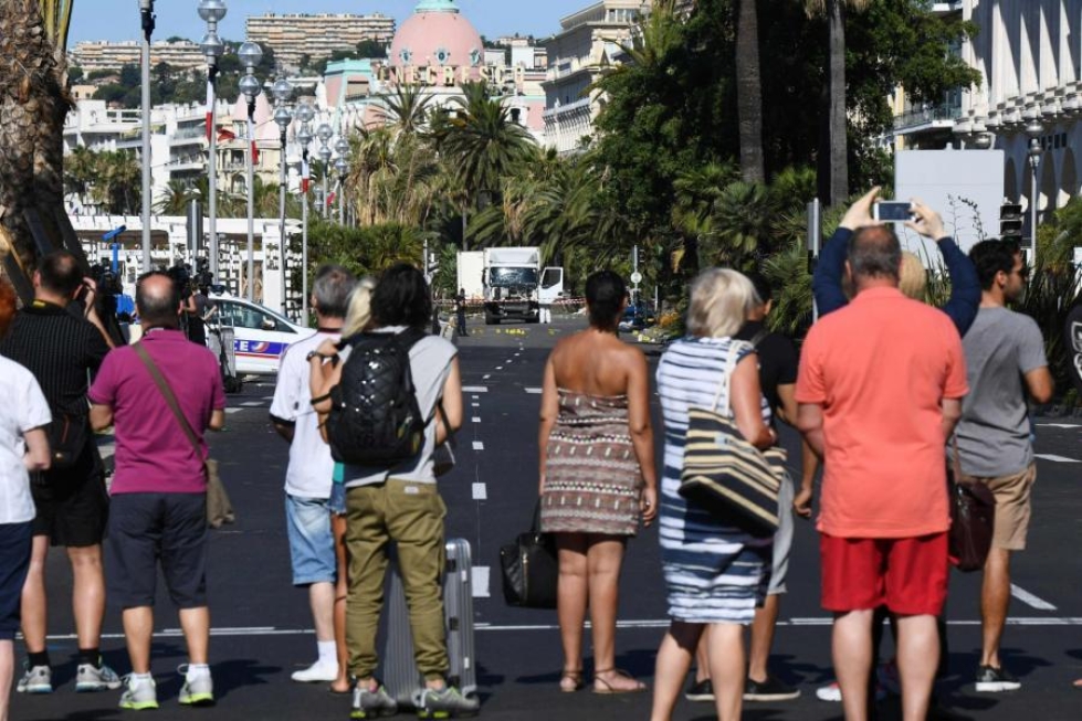 Osa Nizzan kaduilla kulkeneista seurasi tutkijoiden työtä iskupaikalla. LEHTIKUVA/AFP