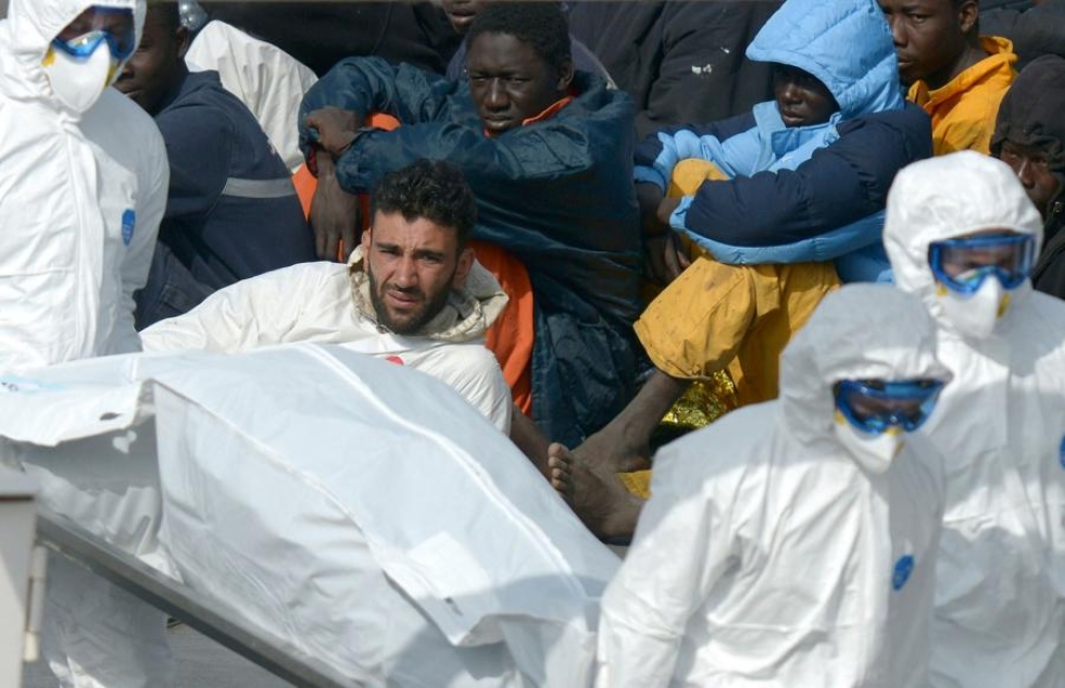 Viime vuoden huhtikuussa otetussa kuvassa Mohammad Ali Malek (keskellä) pelastettujen joukossa Italian rannikkovartion aluksen kannella. LEHTIKUVA/AFP