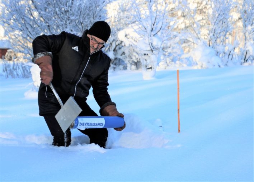 Arkistokuvassa Timo Huttula mittaa lumen syvyyttä ja painoa Tohmajärvellä.