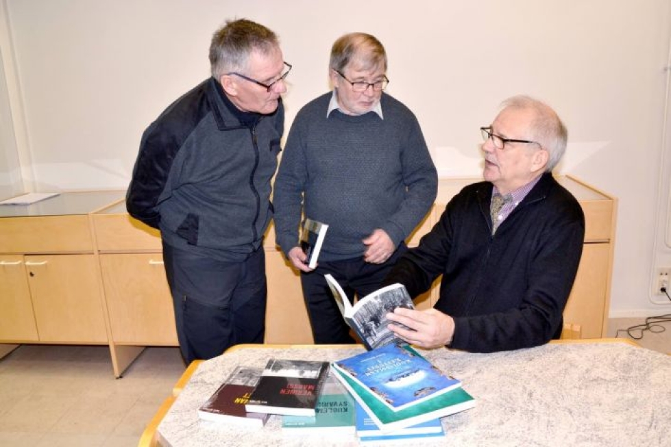Seppo Kärnä, vas. ja Jorma Ikonen kyselivät Ensio Kettusen (istumassa) uusimmasta Itärajan korpisoturit -kirjasta, jota kirjailija esitteli Ilomantsin kirjastolla.