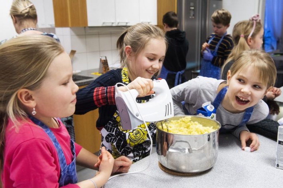 Ella-Maria Koskela (vas.), Eevi Rossi ja Linnea Kauppi valmistavat perunamuussia. Yhdessä kokkaaminen opettaa yhteistyötä.