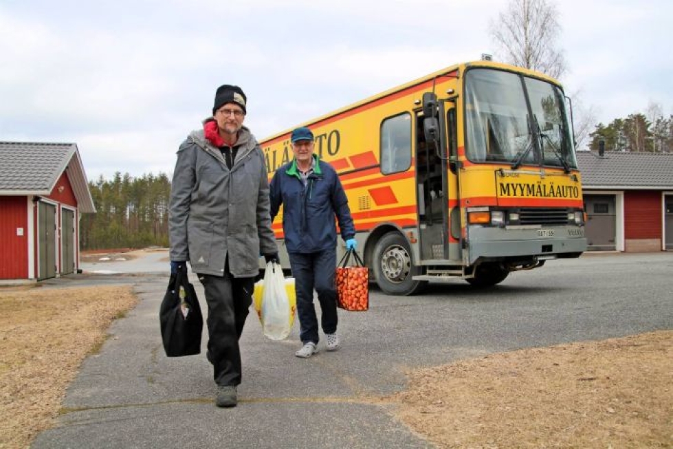 Yrittäjä Markku Hassinen (edessä) kantaa Aimo Anttosen avuksi myymäläauton ostoksia sisälle. Koronaepidemia on lisännyt kaupankäyntiä myymäläautoissa.