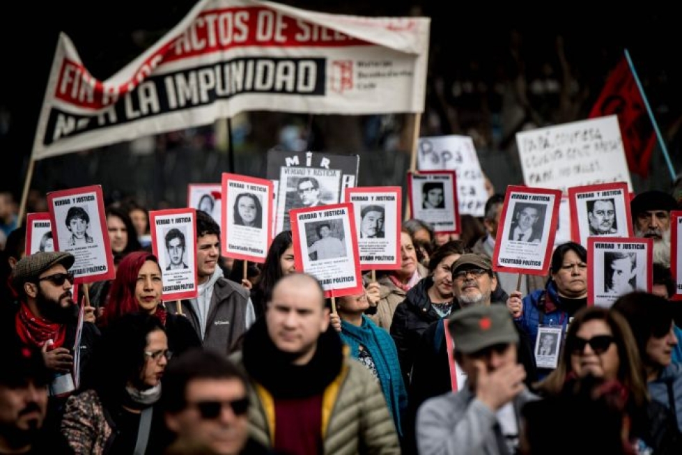 Monet Chilen mielenosoittajat pitelivät kuolleiden ja kadonneiden läheistensä kuvia. LEHTIKUVA/AFP