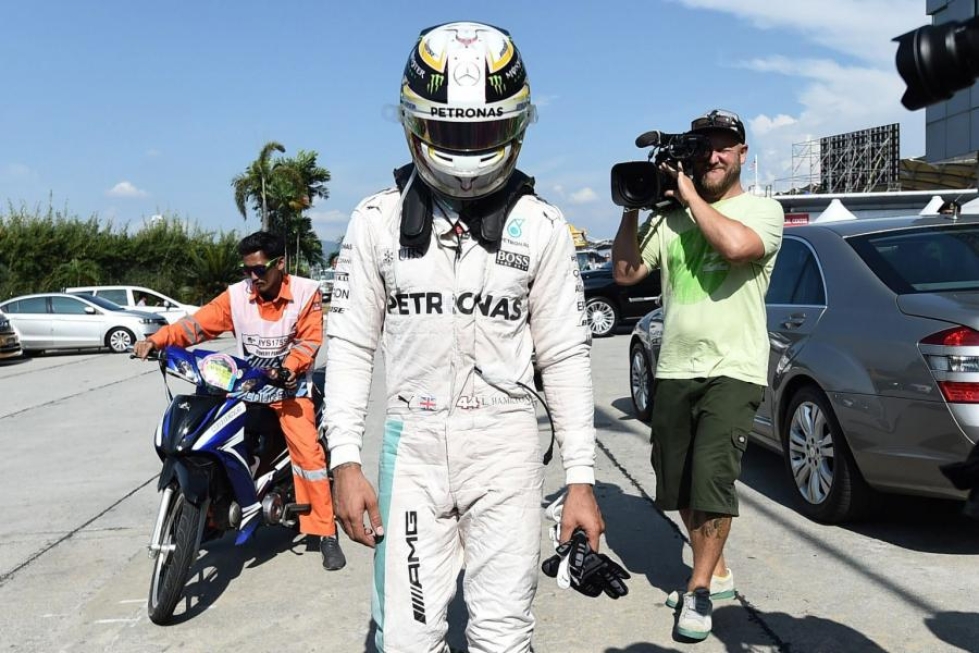 Pettynyt brittikuski Lewis Hamilton matkalla varikolle Malesian gp:ssä. LEHTIKUVA/AFP
