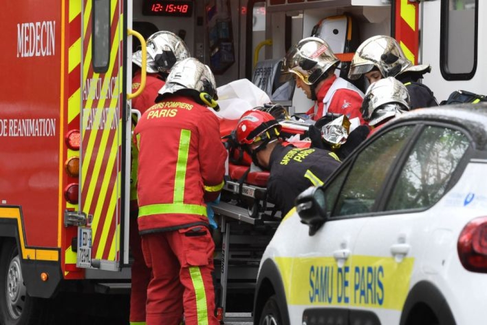 Pariisin iskussa haavoittunutta siirrettiin perjantaina ambulanssiin Charlie Hebdon entisten tilojen lähellä. LEHTIKUVA/AFP