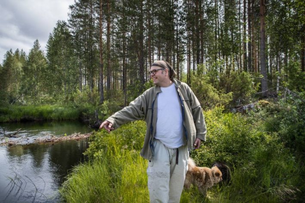 Erikoisluokanopettaja Elias Tanni ja lapinkoira Tupu mutkittelevan Hiienjoen varrella.