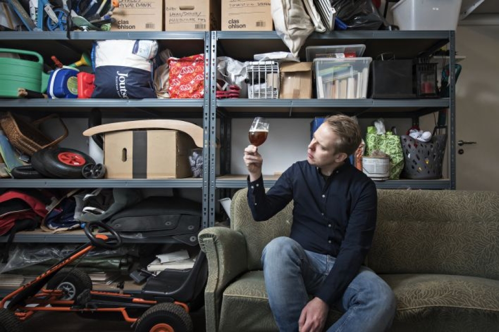 Micke Forsström tutkailee vastavalmistuneen red ale -oluen ulkonäköä kotipanimossaan. Varasto on pullollaan hänen perheensä sekalaista tavaraa.