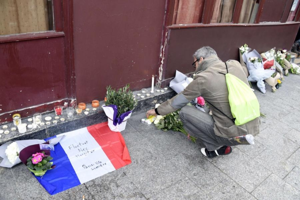 Pariisilaiset toivat kukkia ja kynttilöitä ravintola Carillonin edustalle viime marraskuussa. Jihadistien terrori-isku ravintolaan vaati 12 ihmisen hengen. LEHTIKUVA/AFP