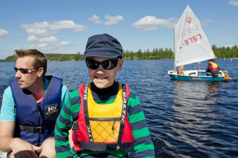 10-vuotias Aki Ryhänen perehtyy purjehduksen saloihin pursiseuralaisten johdolla. Junioripäällikkö Otto Kuivalainen (taustalla) toivoo lajin pariin uusia harrastajia.