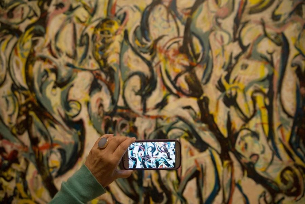 Museovierailija otti kuvia Jackson Pollockin maalauksesta Lontooossa viime viikolla. LEHTIKUVA/AFP