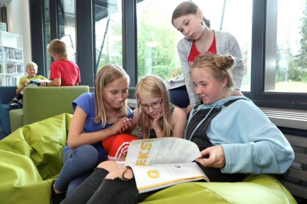 Maisa Kahelin (oik.), Peppi Hiltunen (ylhäällä), Josefiina Haaranen ja Pinja Ryhänen uppoutuvat ryhmätyöhön koulun yhteydessä olevassa kirjastossa.