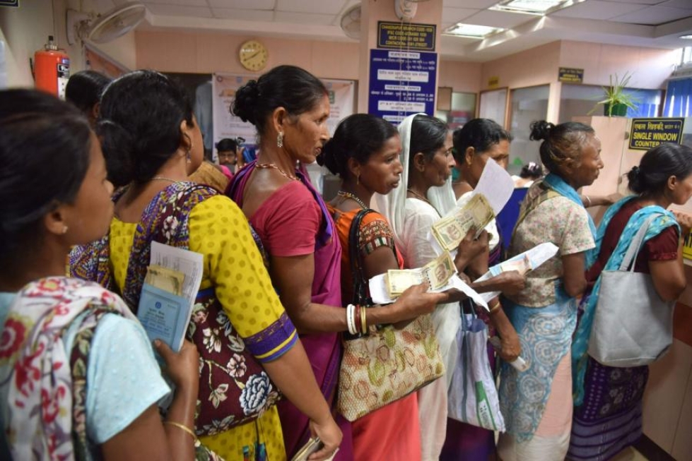 Intilaiset jonottivat pankkiin vaihtaman seteleitään eilen Chandrapurin kylässä. LEHTIKUVA/AFP