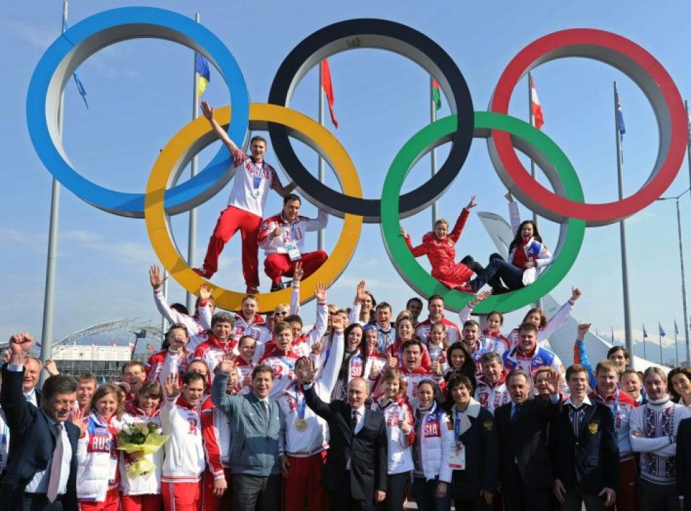 Talviolympialaiset kisattiin Venäjällä Sotshissa 2014. Kuvassa presidentti Vladimir Putin poseeraa venäläisurheilijoiden kanssa olympiarenkaiden alla. LEHTIKUVA/AFP