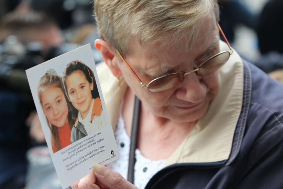 Nainen pitelee käsissään kuvaa kahdesta Dutroux'n uhrista. LEHTIKUVA / AFP