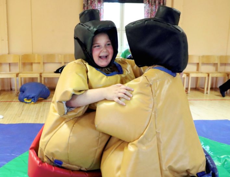 Tuupovaaran nuorisotalolla Vilma Linderman, 9, ja Elli Ronkainen, 9, ottavat toisistaan mittaa sumopuvut päällä.