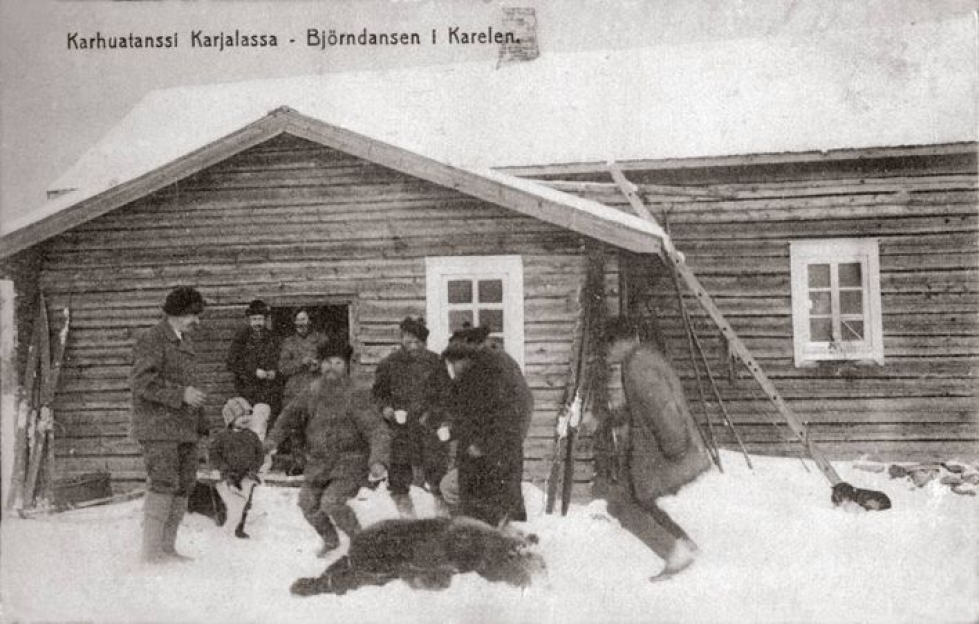 Metsästäjät tanssimassa kaadetun karhun ympärillä jossain päin Karjalaa 1920-luvulla.