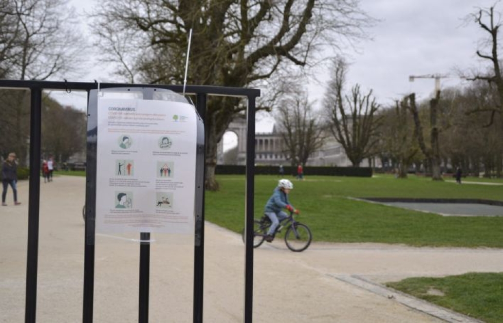Belgiassa Cinquantenaire-puiston porteille on tuotu ohjeistukset muun muassa siitä, että muihin ihmisiin tulisi pitää vähintään 1,5 metrin välimatka. LEHTIKUVA / HETA HASSINEN