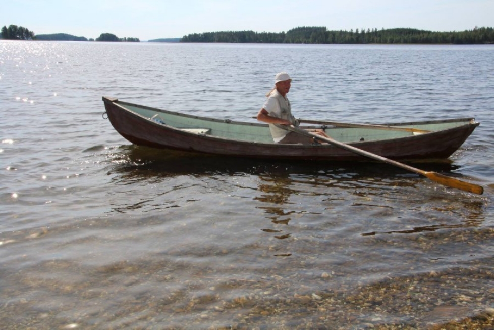 Kesäasukas Juha Luostarinen saa soudella kaislattomalla lahdella Puruvedellä Villalassa.
