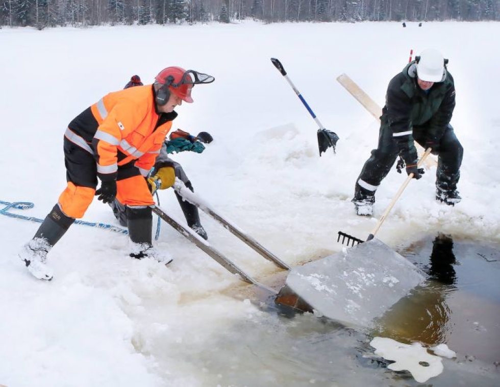 Nousihan se. Kyösti Nykänen, Tenho Turunen ja Tapio Brelo kampeavat 500 kilon jäämurikkaa nostoteloille. Brelo sahasi kuutiot irti moottorisahalla.