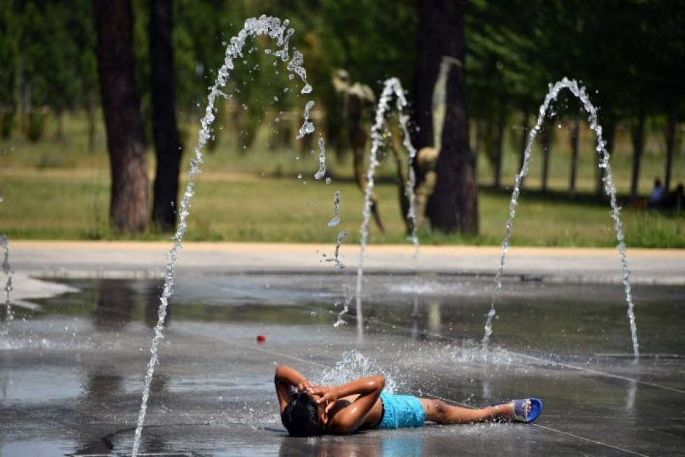 Lapsi vilvoittelee puistossa Montpellierissä Ranskassa. Lehtikuva/AFP