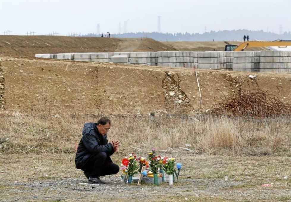 Mies rukoili Fukushiman uhrien puolesta Japanissa maaliskuussa 2011.