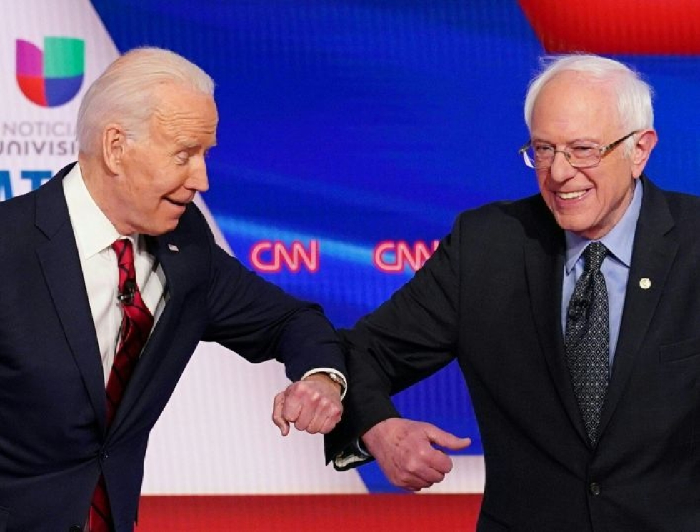 Koronaviruksen leviäminen sai demokraattien presidenttiehdokkaat Joe Bidenin (vasemmalla) ja Bernie Sandersin korvaamaan kättelyn kyynärpääkopautuksella. Lehtikuva/AFP