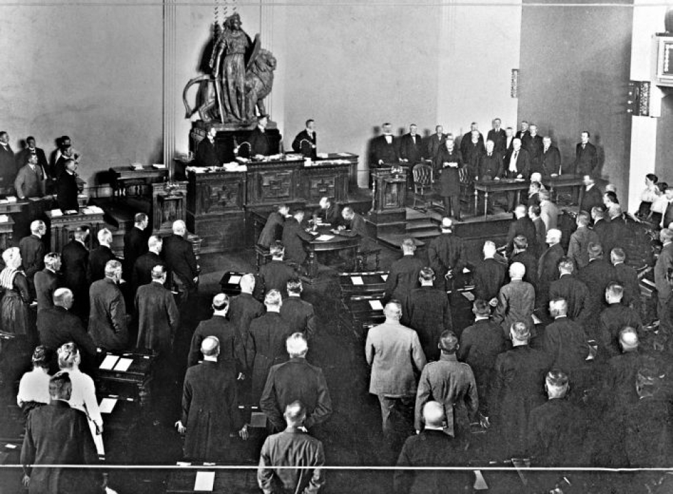 Tasavallan ensimmäiseksi presidentiksi valittu K.J. Ståhlberg lukee presidentinvakuutuksensa eduskunnan juhlaistunnossa Heimolan istuntosalissa, vuonna 1919.