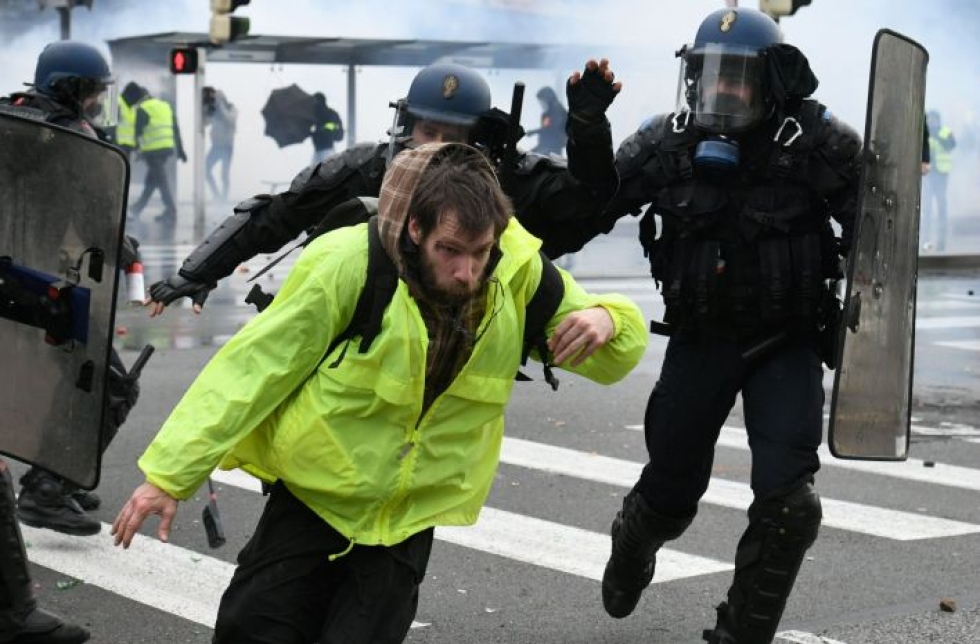 Mellakkapoliisit juoksivat mielenosoittajan perässä Länsi-Ranskan Quimperissa, jossa noin 800 keltaliiviä osoitti lauantaina mieltään. LEHTIKUVA/AFP