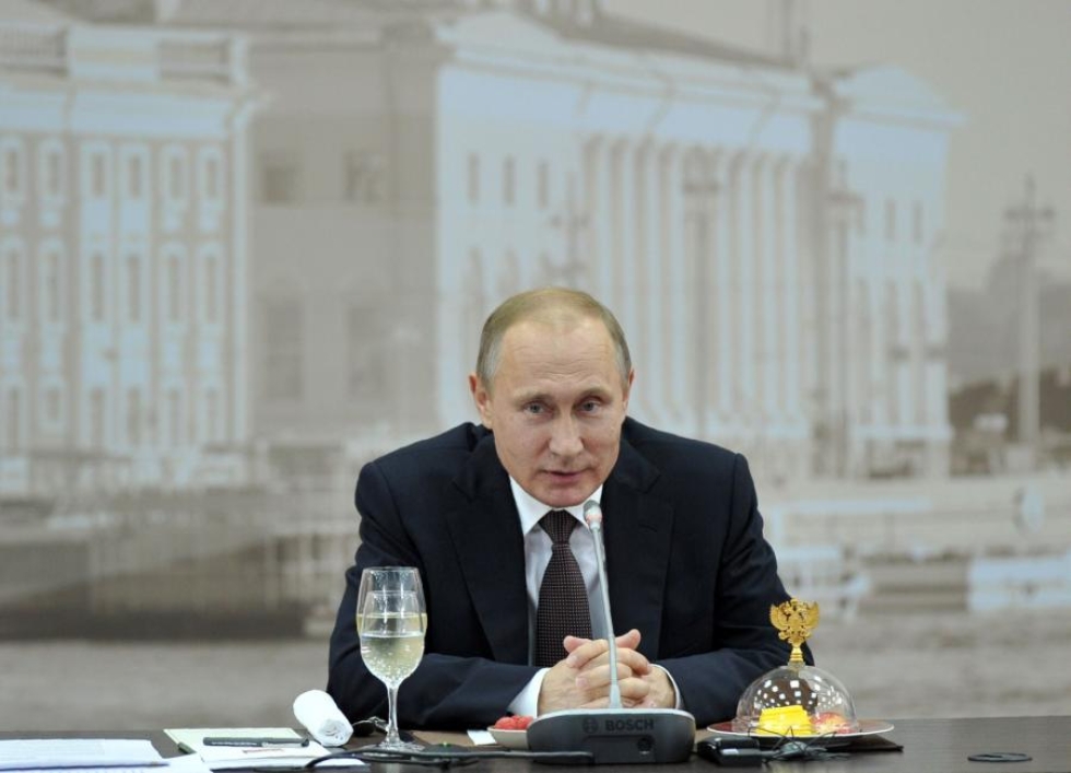 Venäjän presidentti Vladimir Putin ihmettelee, miten venäläisfanit pystyivät pieksemään suuren määrän englantilaisia. LEHTIKUVA/AFP