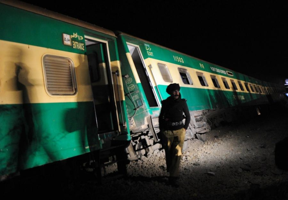 Junaturmat eivät ole harvinaisia Pakistanissa. Kuvassa poliisi raiteilta suistuneen junan edessä Karachissa helmikuussa 2014. LEHTIKUVA/AFP