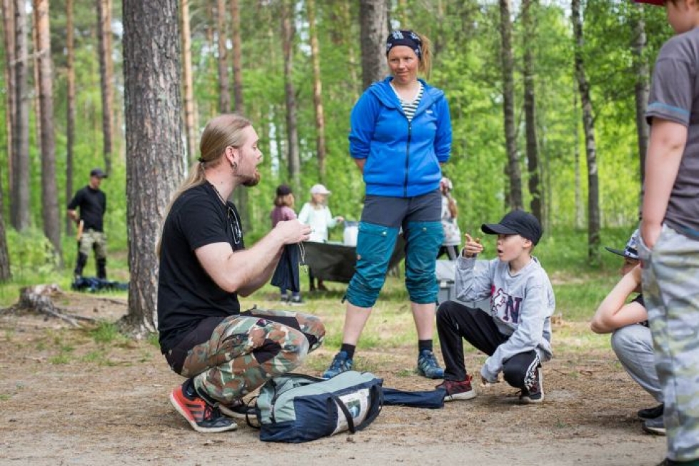 Nuoriso-ohjaajat Mirko Byman ja Henna-Riikka Uuksulainen antavat kerholaisille neuvoja teltan pystytykseen. Elmeri Ruohola, 9, kuuntelee tarkkaavaisesti.
