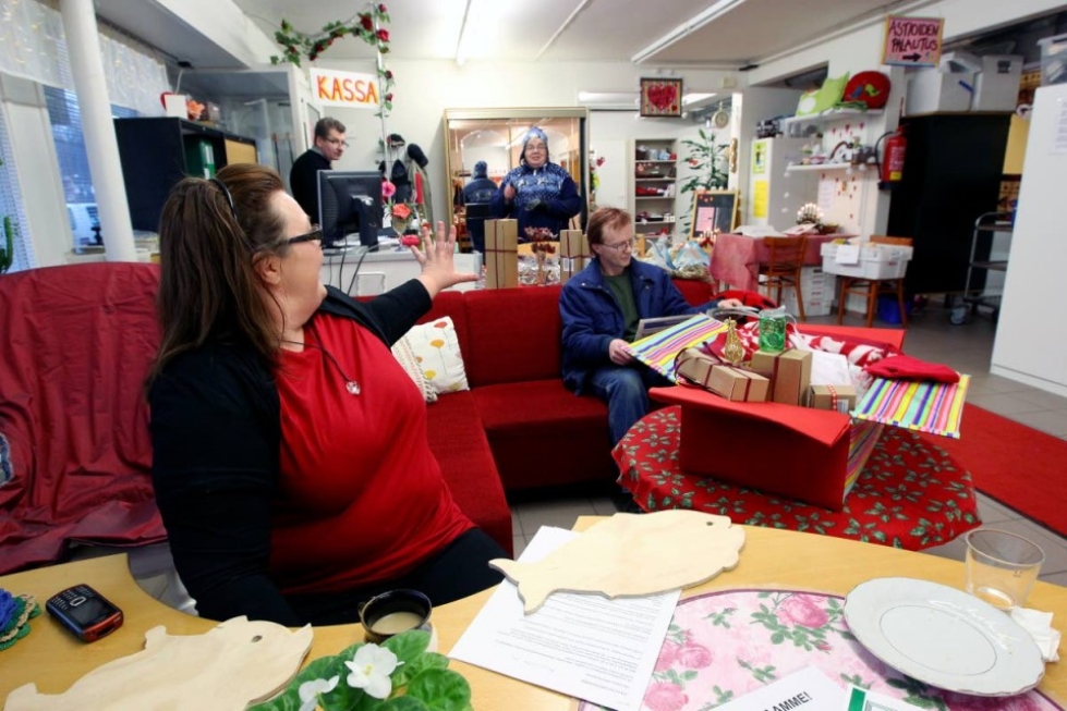 Parempi Arki ry:n toimitilat Enon keskustassa ovat aktiivisessa käytössä. Toiminnanjohtaja Anna-Liisa Pieviläinen tervehtii tulijoita iloisesti. Kuvan oikeassa laidassa näkyy joululaatikko, jollaisiin kerätään lahjoituksia.