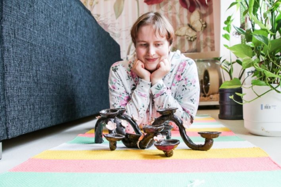 Susanna Kokkonen suunnitteli ja toteutti savityökurssilla kukkaköynnöksen, jossa on paikkoja tuikuille. Myös matto on hänen itsensä kutoma.