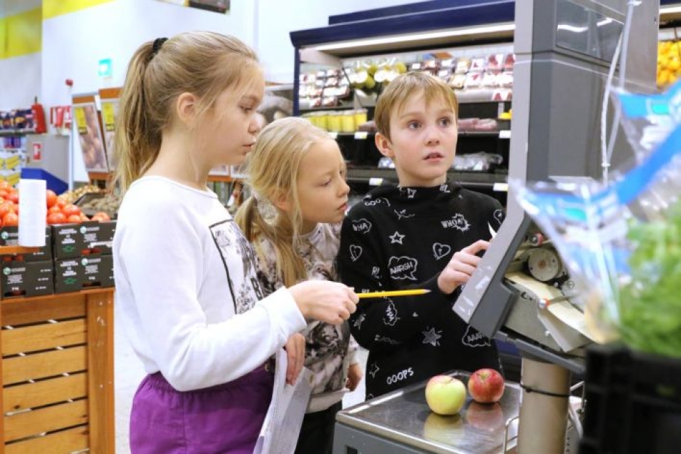 Lieksan keskuskoulun oppilaat Siiri Turpeinen, Alisa Homanen ja Topi Muikku tarkistivat, paljonko omenat maksavat.