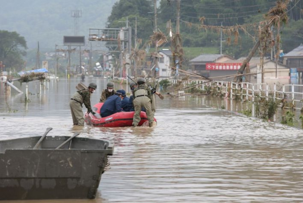 Japanissa viranomaiset ovat joutuneet käyttämään kumiveneitä päästäkseen liikkumaan rankkasateiden aiheuttamien tulvien keskellä. Lehtikuva/AFP