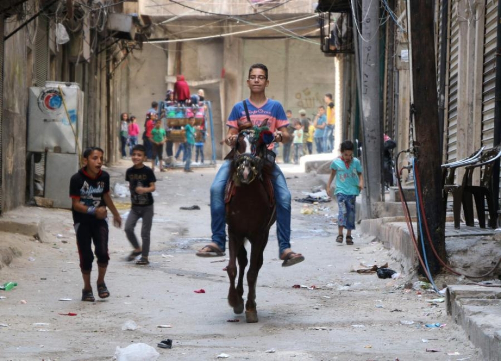 Syyrialaispoika ratsastaa Aleppon kadulla. Alkuviikosta voimaan tullut tulitauko näyttää edelleen pääosin pitävän. Lehtikuva/AFP