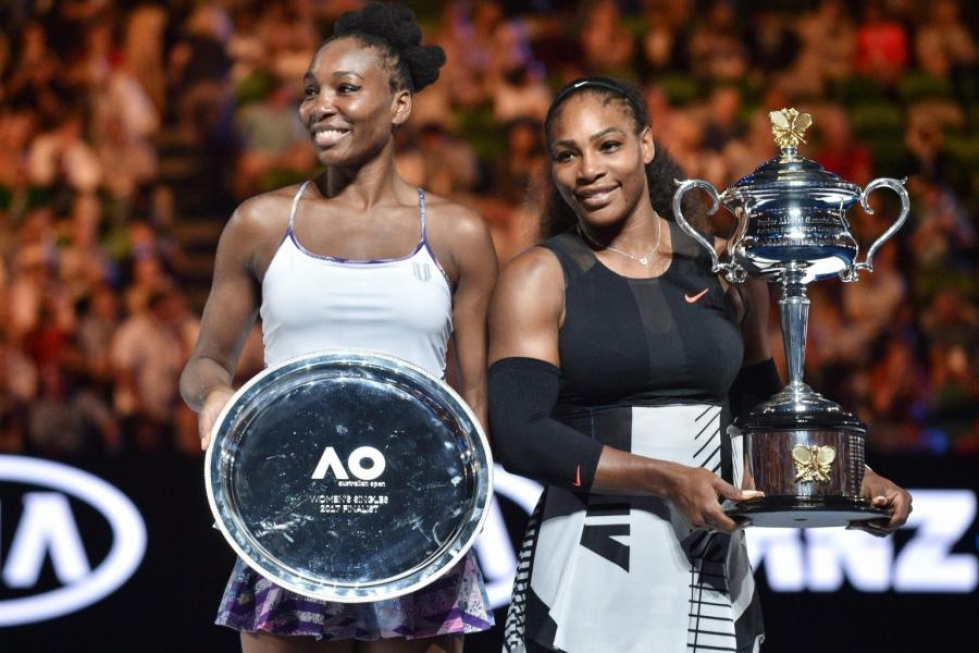 Serena Williams (oik.) juhli voittoaan siskonsa Venuksen rinnalla. LEHTIKUVA/AFP