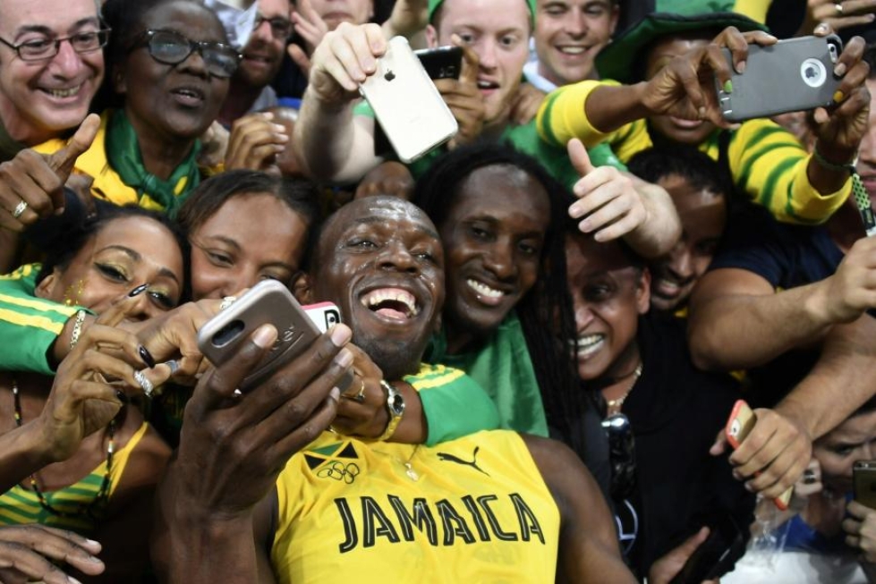 Usain Bolt juhli voittoaan faniensa ympäröimänä. LEHTIKUVA/AFP