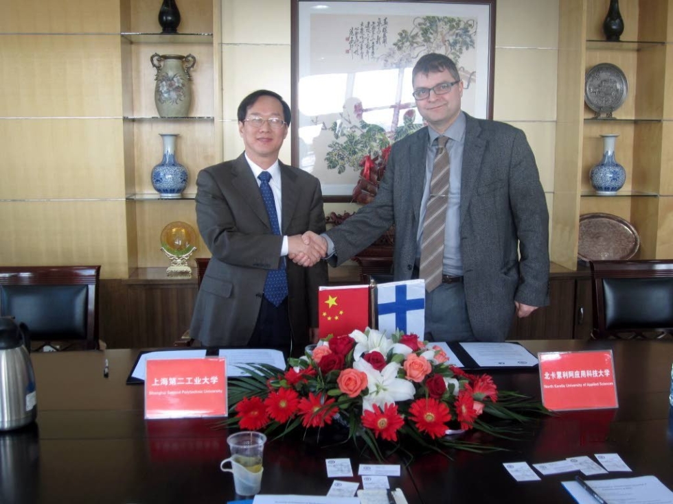 Vararehtori Zou Long Fei (Shanghai Second Polytechnic University) ja rehtori Petri Raivo (PKAMK) löivät kättä oppilaitostensa yhteistyön merkiksi.