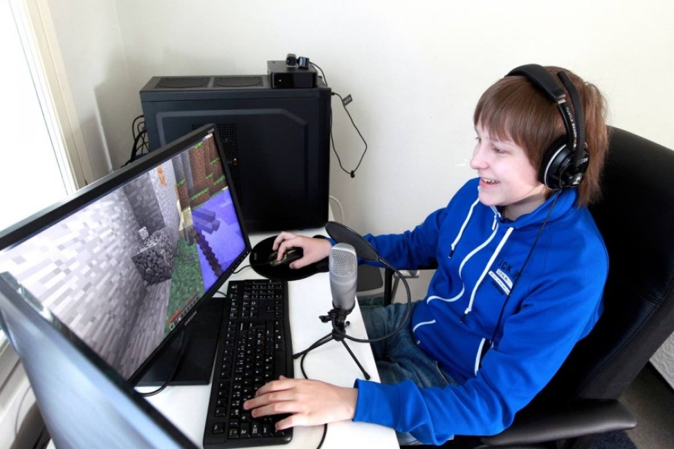 Aleksi Koli  ja pelattava Minecraft-peli. Hän selostaa pelejä ja opastaa samalla aloittelijat pelien kiemuroihin.