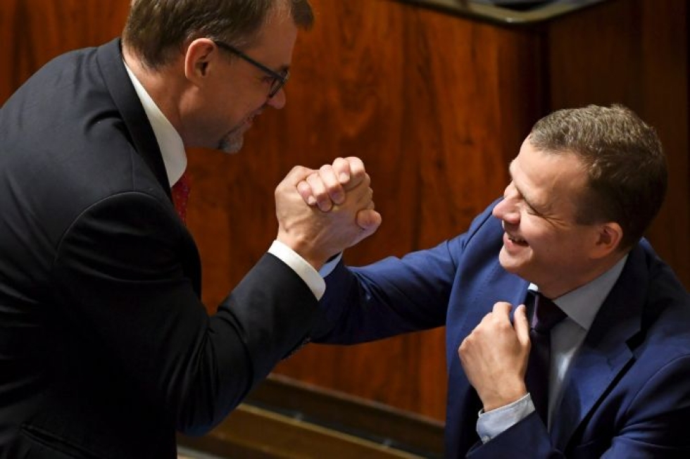 Pääministeri Juha Sipilä (kesk.) ja valtiovarainministeri Petteri Orpo (kok.) löivät kättä eduskunnan täysistunnossa joulukuussa. LEHTIKUVA / JUSSI NUKARI