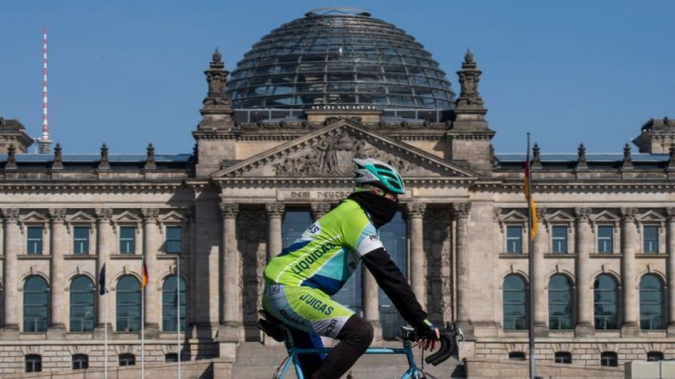 Mies pyöräili Saksan parlamenttirakennuksen ohi Berliinissä. LEHTIKUVA / AFP