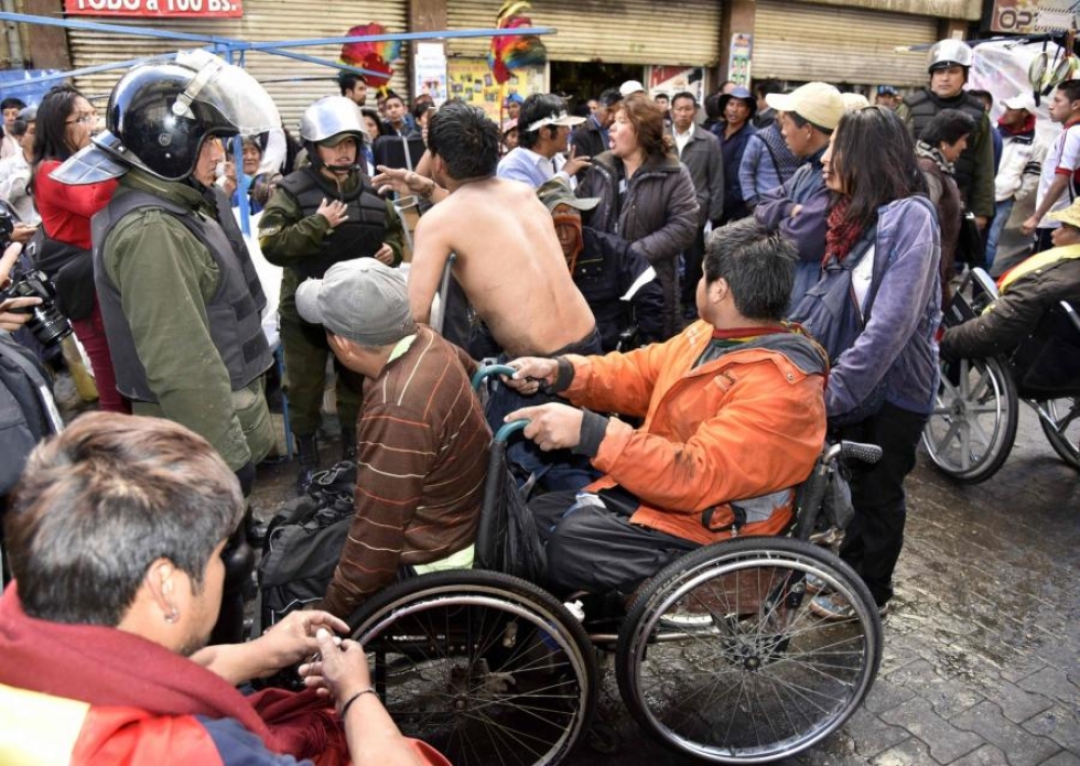 Pyörätuoleilla liikkuvia mielenosoittajia estettiin eilen etenemästä Bolivian presidentinpalatsin luo. Mielenosoittajat ovat leiriytyneet Bolivian pääkaupungin La Pazin keskustassa jo kuukauden. LEHTIKUVA/AFP