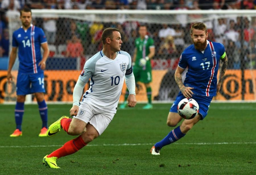 Palloa tavoittelemassa Englannin Wayne Rooney ja Islannin Aron Gunnarsson. LEHTIKUVA/AFP