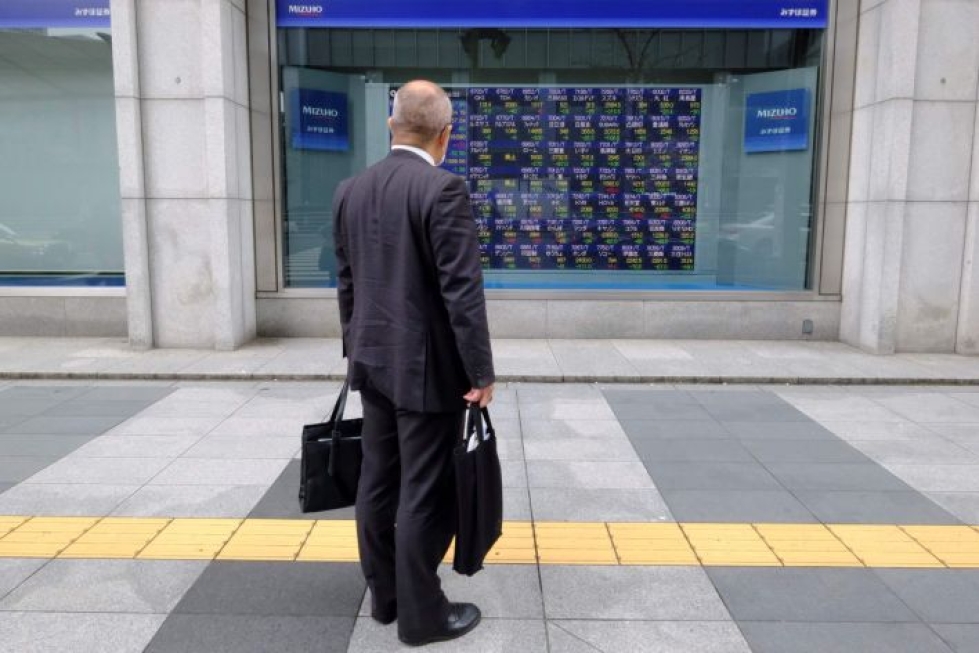 Mies tutkii Tokion pörssin kurssikehitystä seuraavaa näyttöä. LEHTIKUVA/AFP