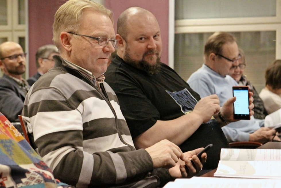 Perussuomalaiset Osmo Pirhonen (vas.) ja Marko Koskinen hankkivat puhelimitse lisätietoa kesken kokouksen.