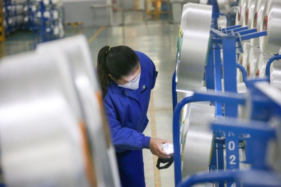 Suojavälineiden valmistus Kiinassa on alkanut hiipua keväisestä yllätyspiikistään. Lehtikuva/AFP