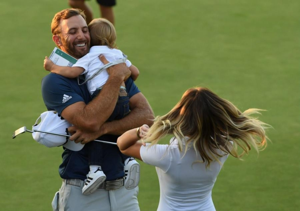 Dustin Johnson iloitsi ensimmäisestä US Openin voitostaan perheensä kanssa. LEHTIKUVA/AFP