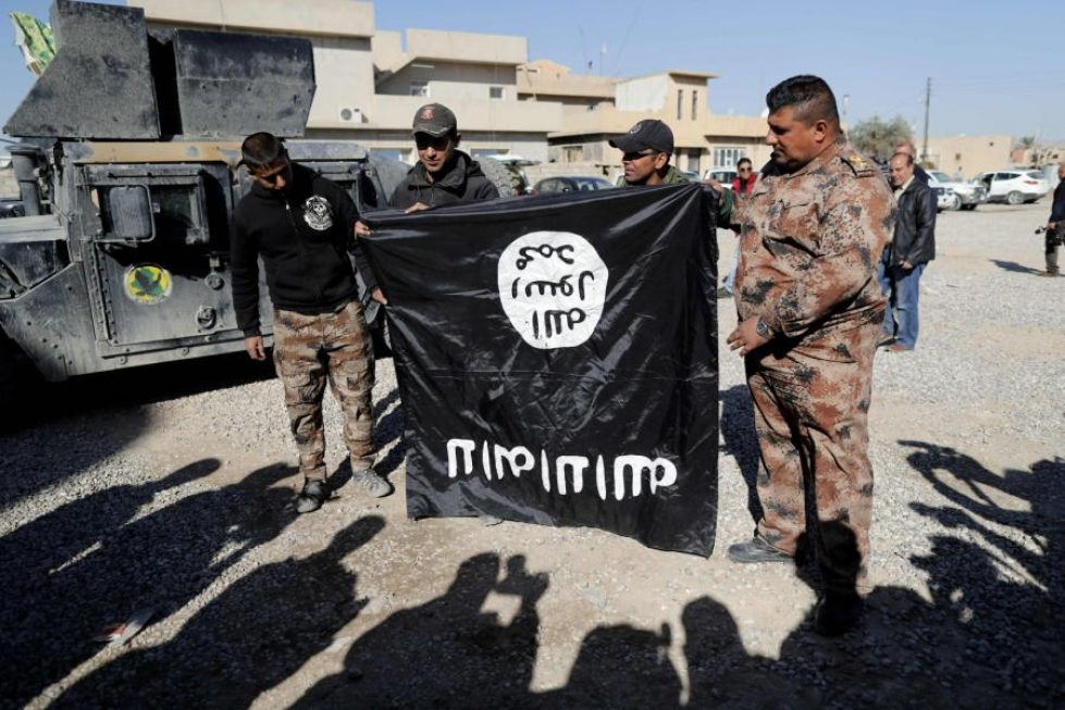 Irakin armeijan sotilaat esittelivät ylösalaisin jihadistijärjestö Isisin lippua eilen Mosulin esikaupungissa. LEHTIKUVA/AFP